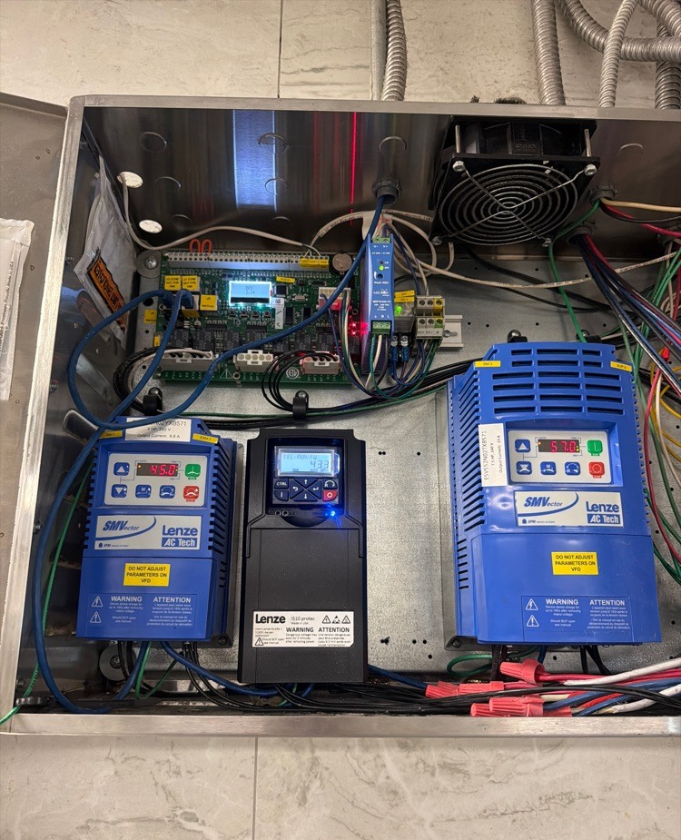 Commercial kitchen exhaust and hood control panel with variable frequency drives under service